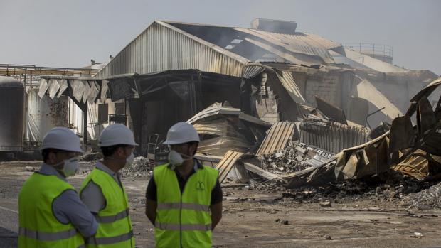 Tres operarios junto a la zona afectada por el incendio