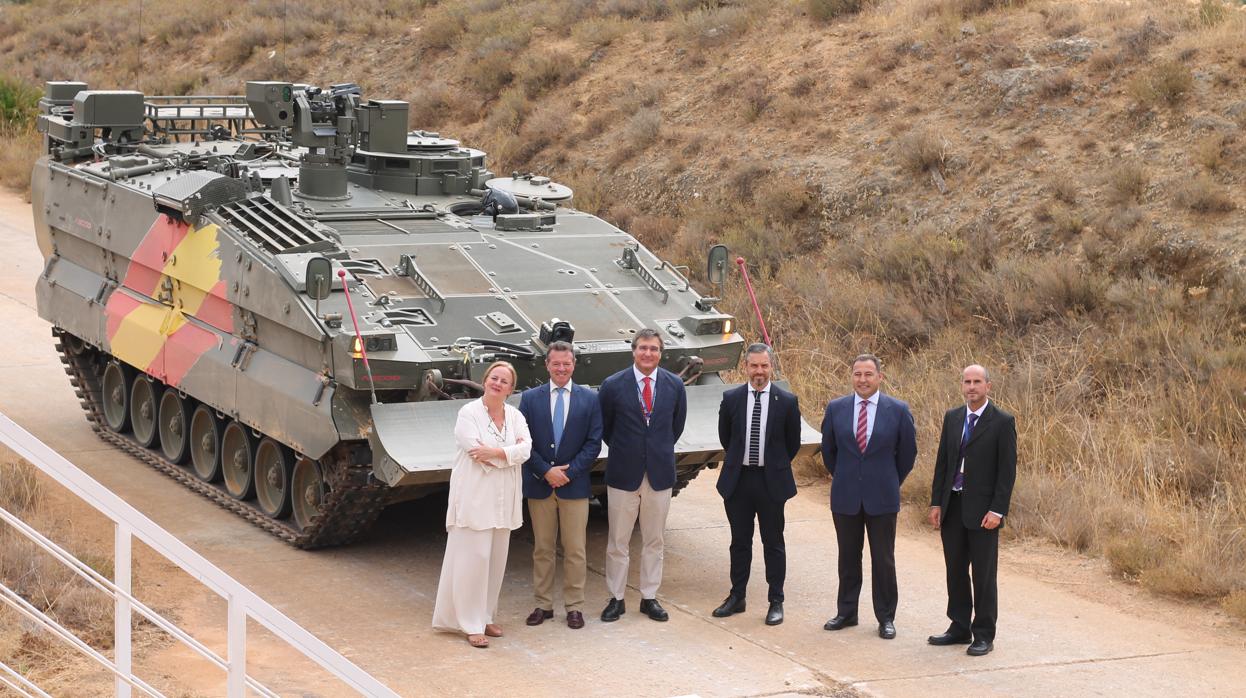 El consejero de Hacienda, Industria y Energía, Juan Bravo (tercero por la is¡zquierda), junto a un carro blinddao en la planta de SBS de Alcalá, junto a otros responsables