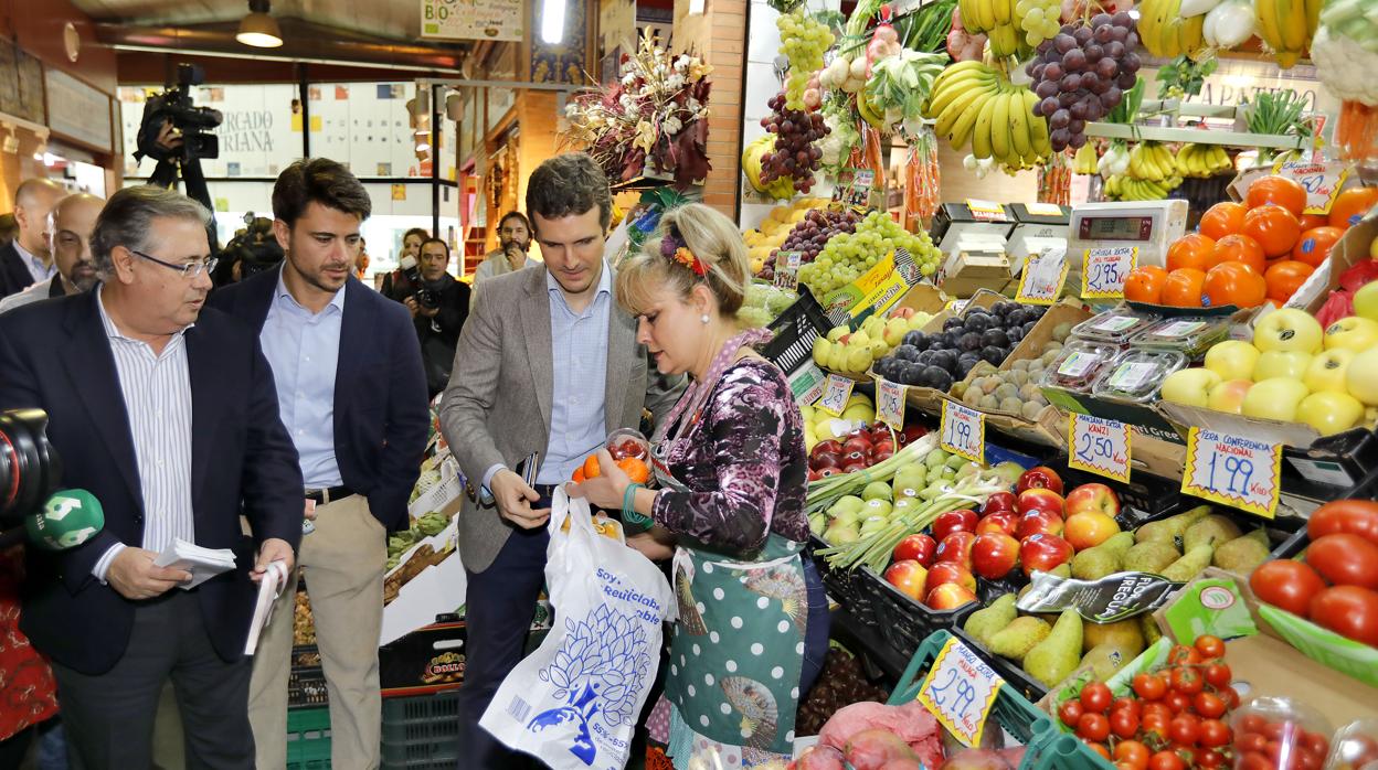Zoido, Beltrán Pérez y Pablo Casado comprando fruta en el Mercado de Triana