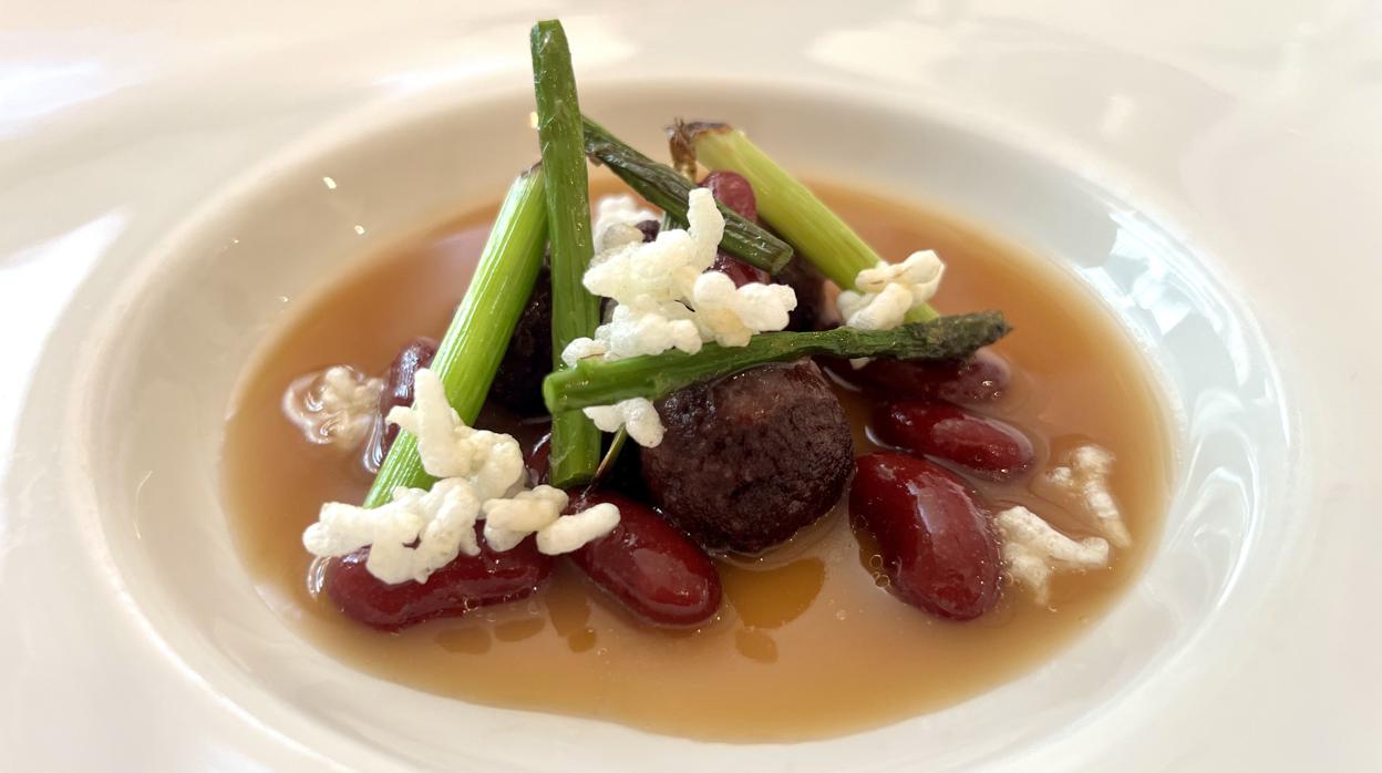 Botones de morcilla asturiana con caldo tibio de jamón, alubias rojas y arroz inflado