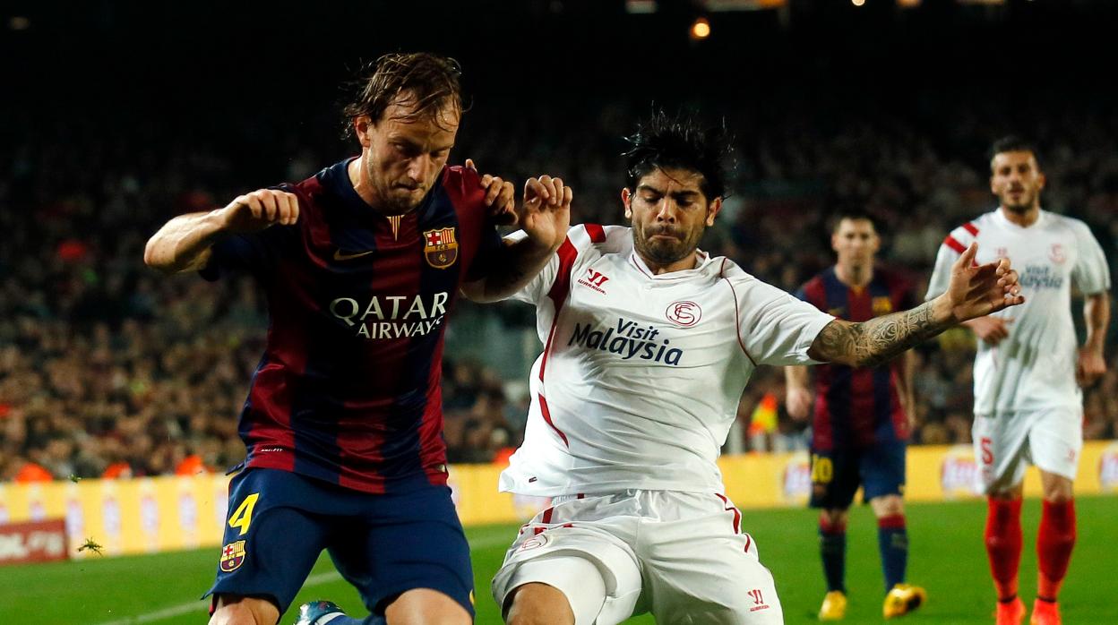 Rakitic y Banega pelean un balón durante un Barcelona-Sevilla