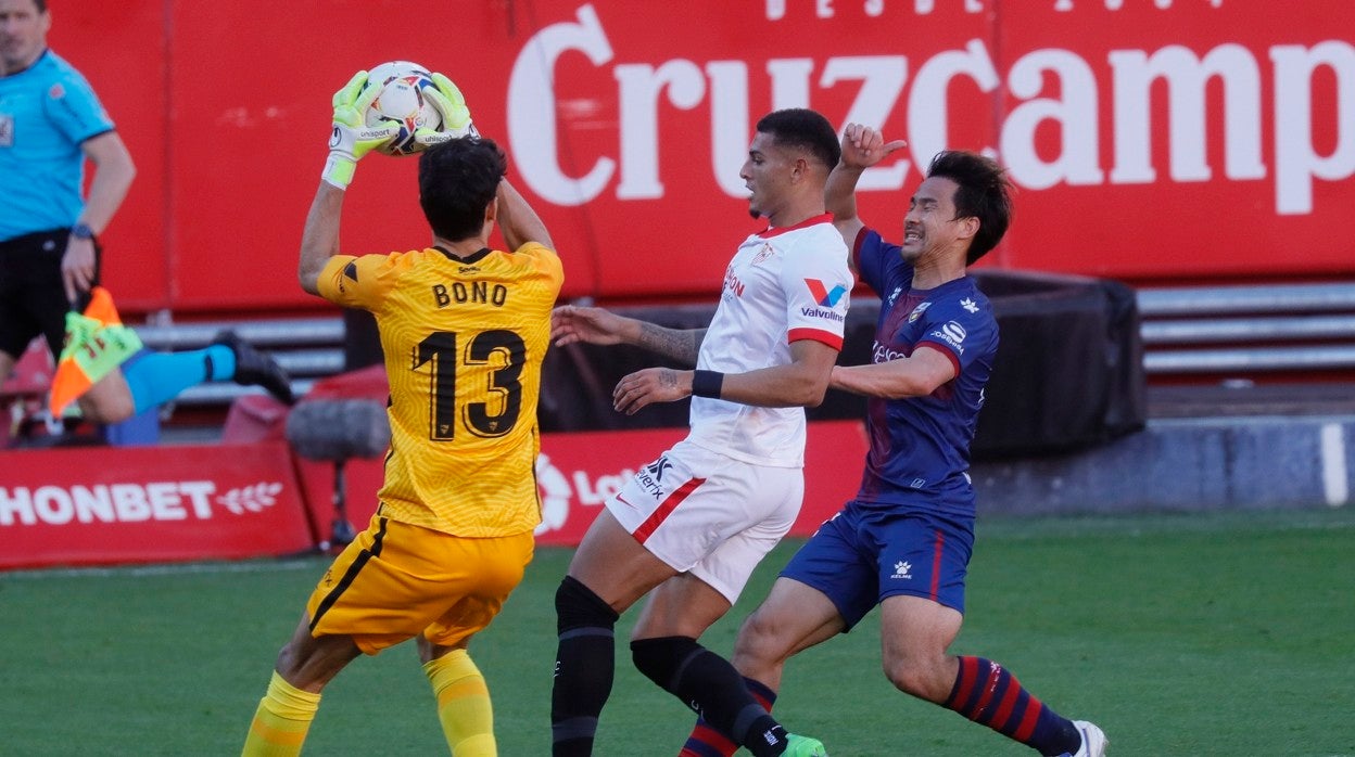 Bono atarpa un balón ante Diego Carlos y Okazaki en el Sevilla - Huesca