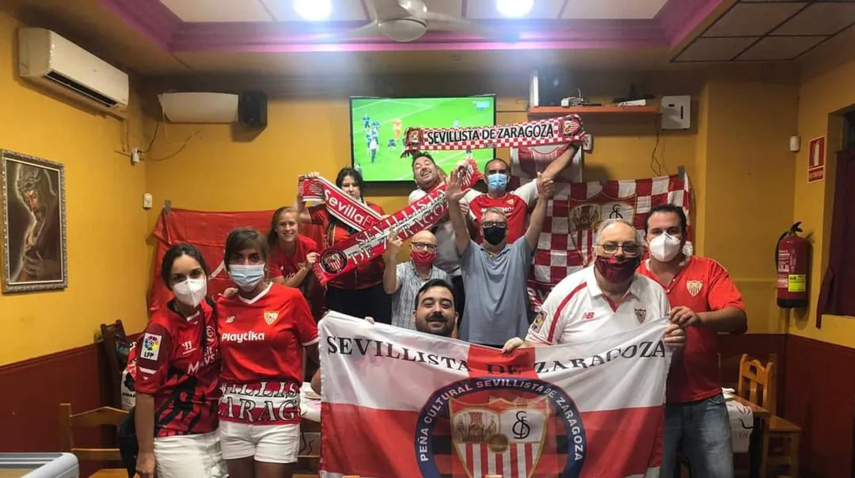 Integrantes de la 'Peña Cultural Sevillista de Zaragoza' celebran la consecución de la sexta Europa League por parte del Sevilla FC desde su bar de confianza