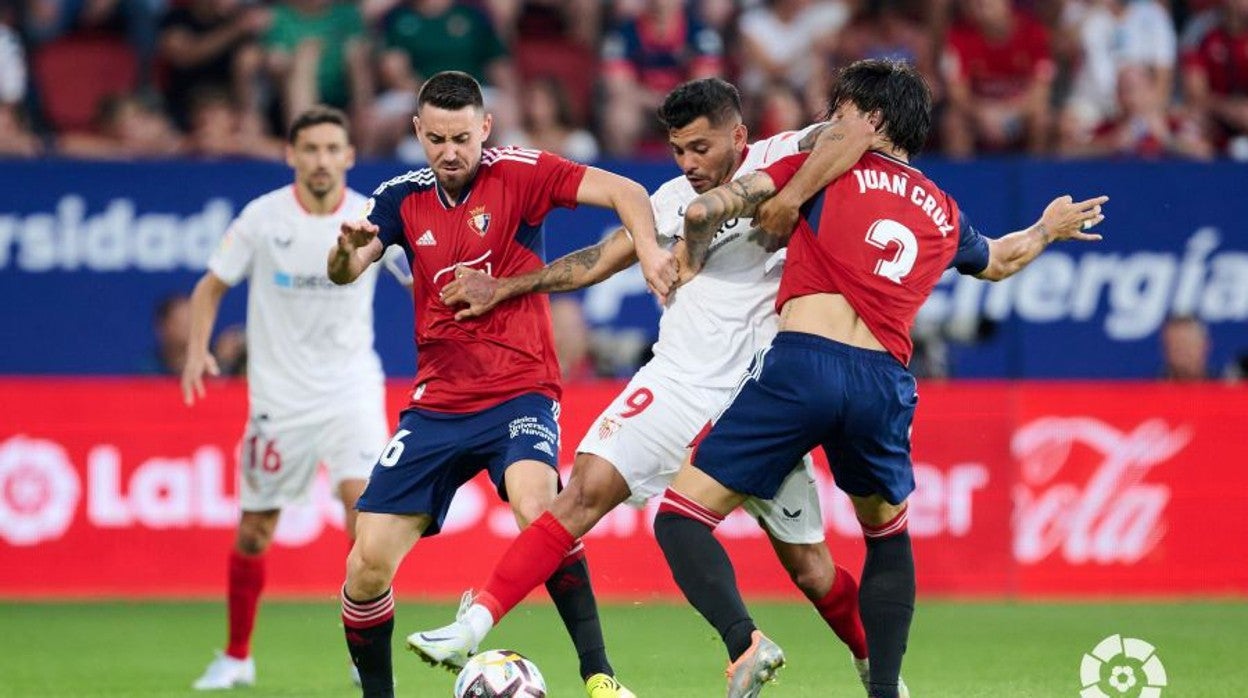 Tecatito Corona pugna con Juan Cruz y Moi Gómez durante el Osasuna - Sevilla