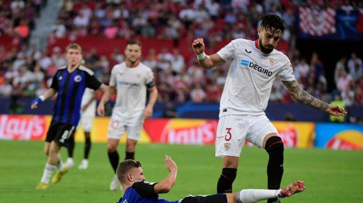 El sevillista Telles intenta zafarse de la entrada del jugador del Copenhague Jelert