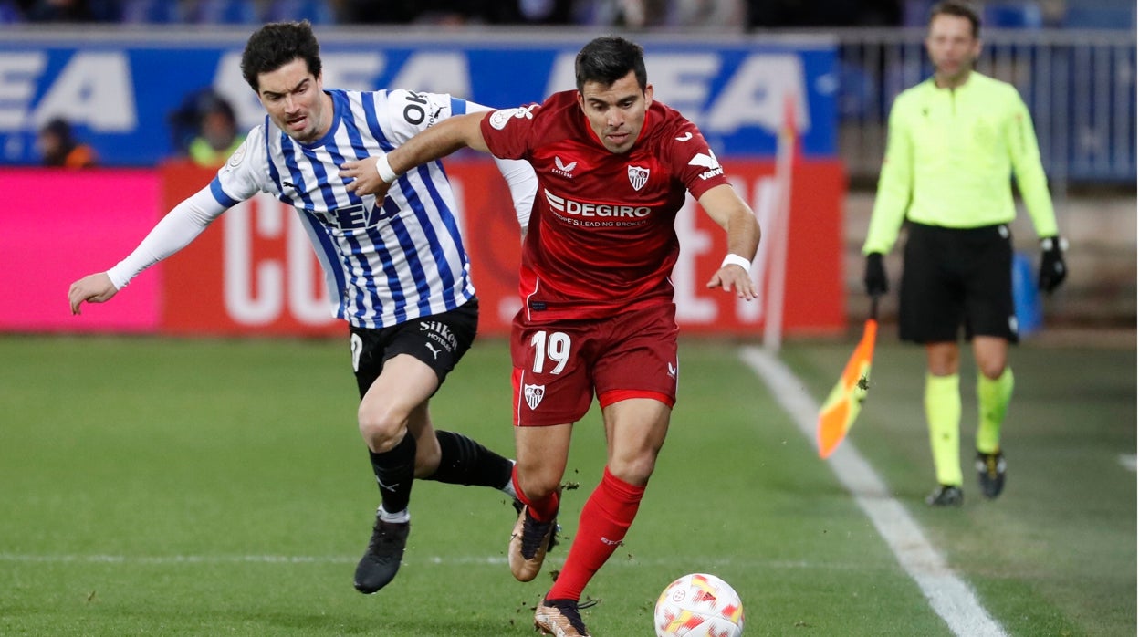 El centrocampista argentino del sevilla Marcos Acuña pelea un balón con el centrocampista del Alavés Jason