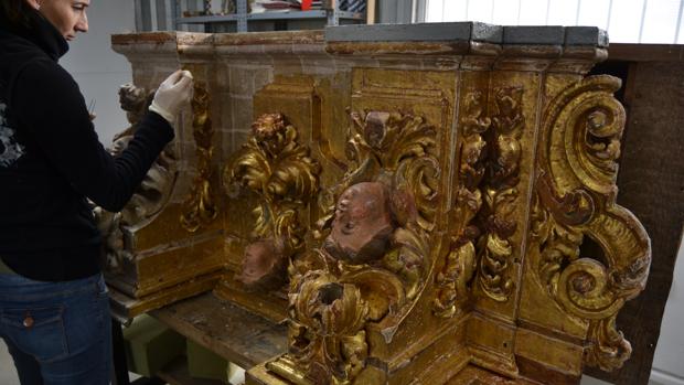 Una restauradora trabajando en una de las piezas del retablo del Rosario