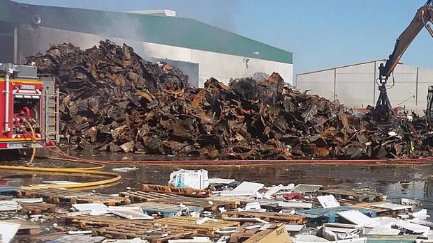 Los bomberos, junto a los restos calcinados