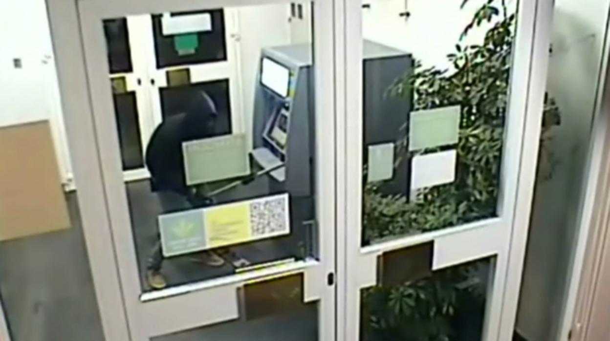 Imagen del detenido manipulando uno de los cajeros automáticos
