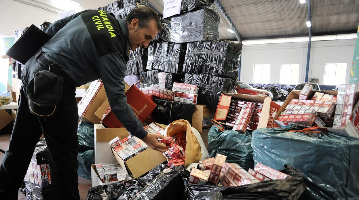 Un agente de la Guardia Civil muestra el tabaco de contrabando intervenido en una operación