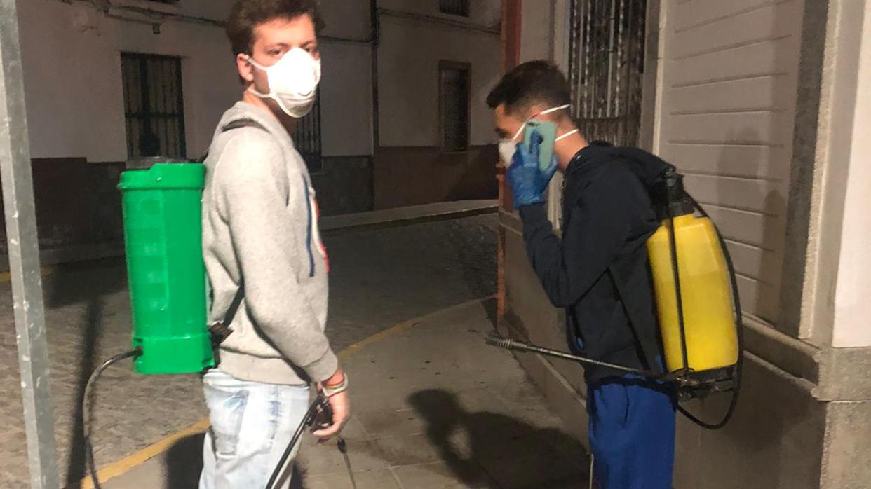 El alcalde de Los Molares, a la izquierda, fumigando la calles de la localidad sevillana