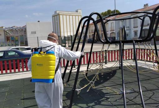 Un operario realiza labores de desinfección en un parque infantil de El Coronil