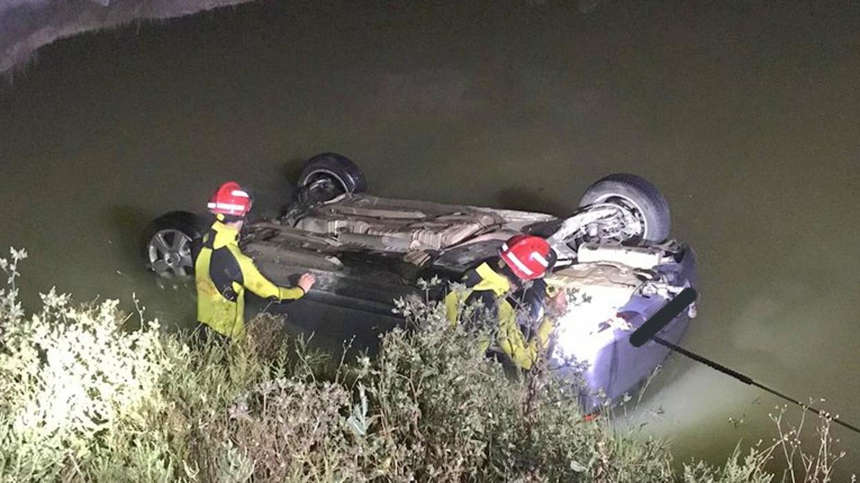 Dos bomberos rescatan del canal de riego el vehículo siniestrado