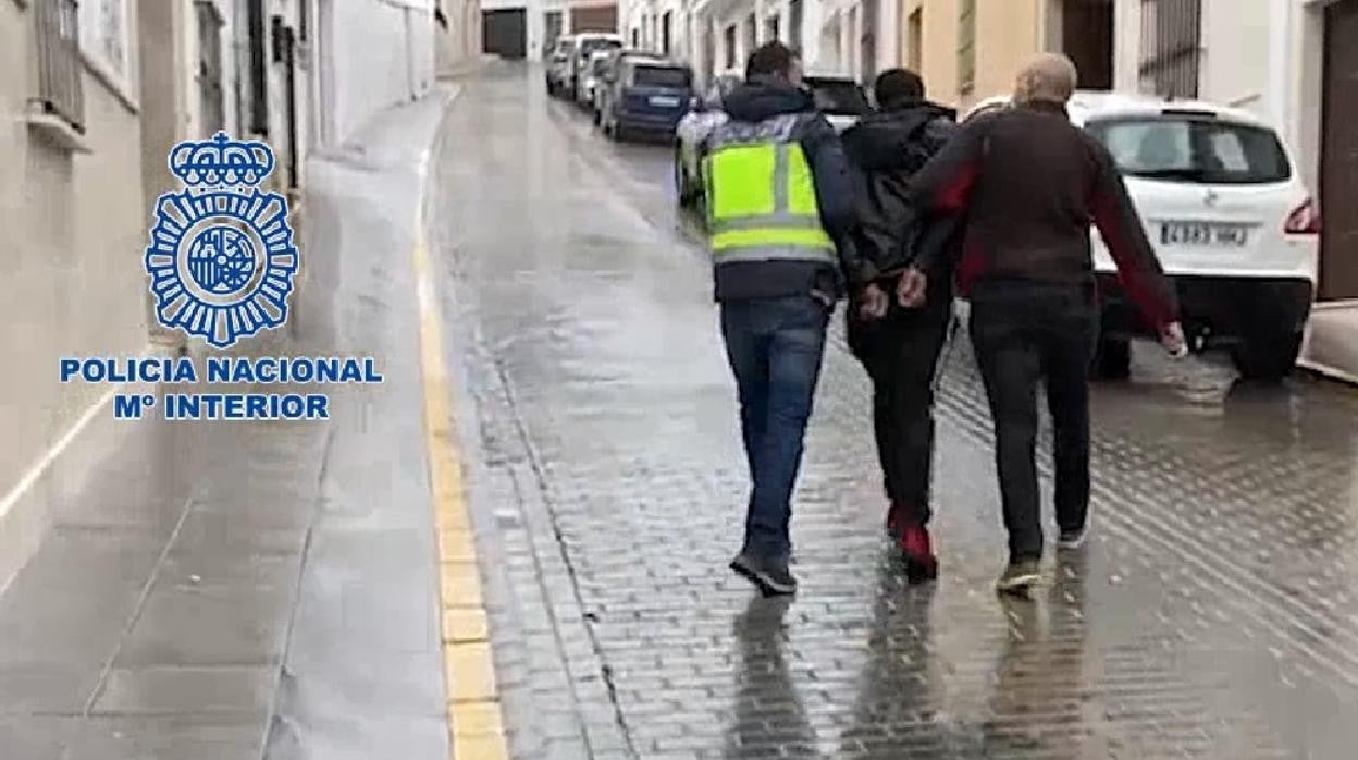 Dos agentes llevan al detenido esposado hasta el vehículo policial