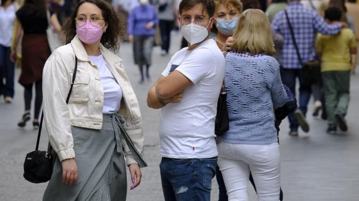Viandantes con mascarillas en una céntrica calle de Sevilla