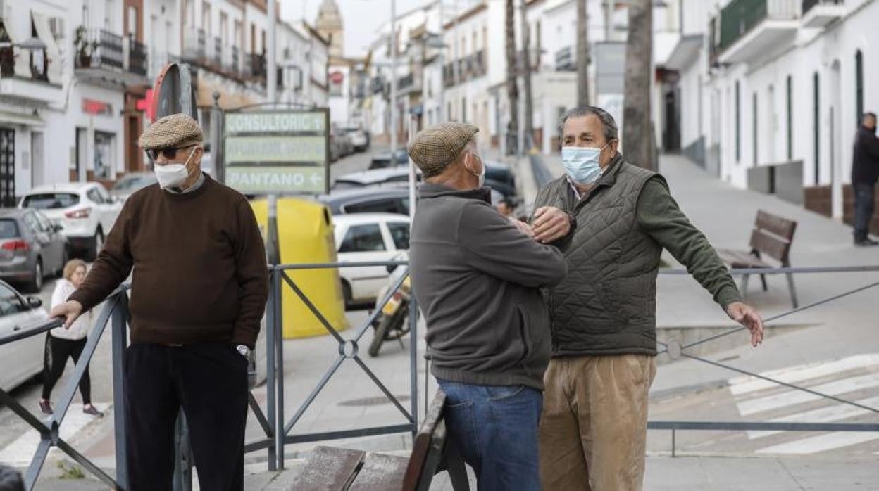 Tres vecinos de Aznalcóllar dialogan en una calle del municipio