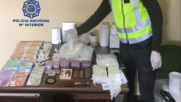 Un agente muestra la droga y el dinero intervenido en la operación policial