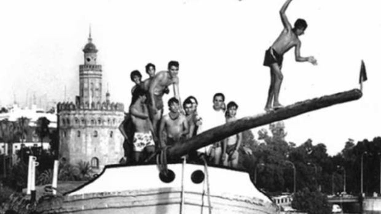 Jóvenes compitiendo en la cucaña a orillas del Guadalquivir