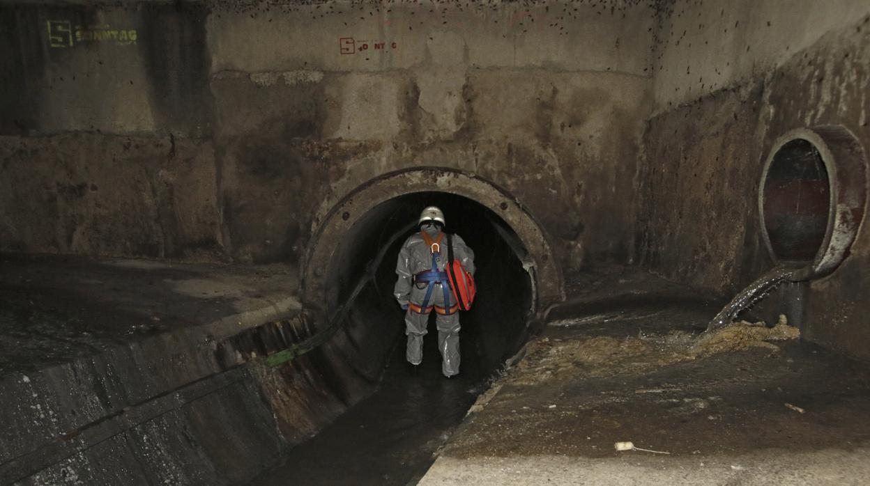 Uno de los agentes se adentra en un colector