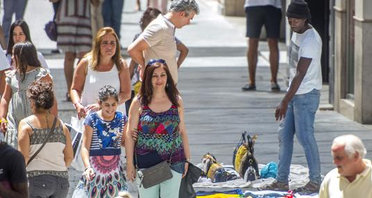 Un mantero muestra un artículo a un hombre
