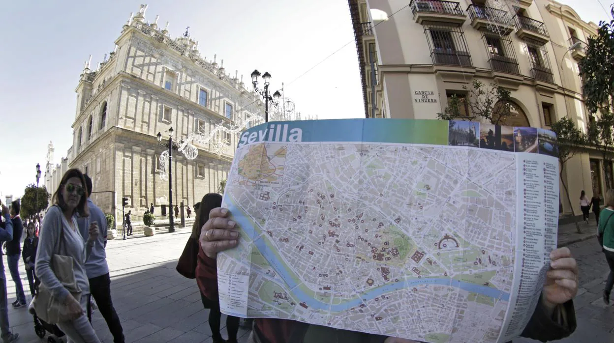 Dos turistas consultan un mapa de Sevilla en el Casco Histórico