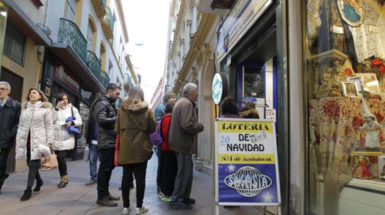 Clientes en la puerta de un despacho de loterías de la capital