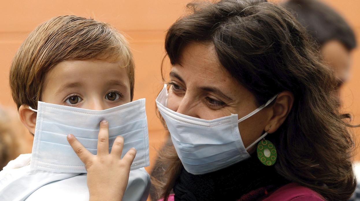 Un niño se cubre el rostro con una mascarilla inadecuada, tanto por las dimensiones como por las zonas abiertas al contagio