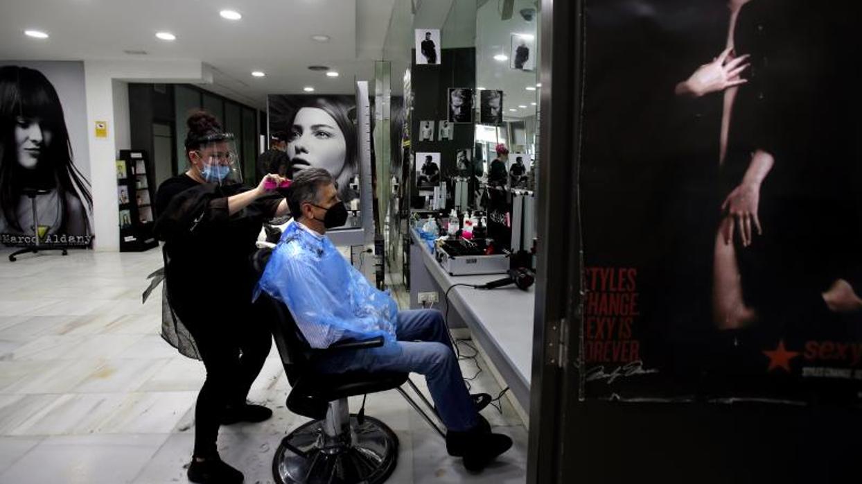 Un barbero arregla a un cliente en una barbería de Sevilla el lunes 4 de mayo