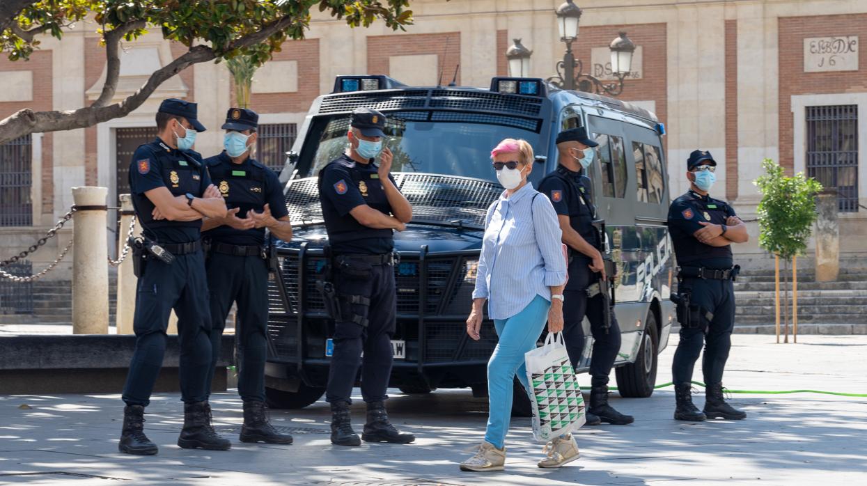 Una mujer pasea junto al Archivo de Indias en presencia de cinco policías