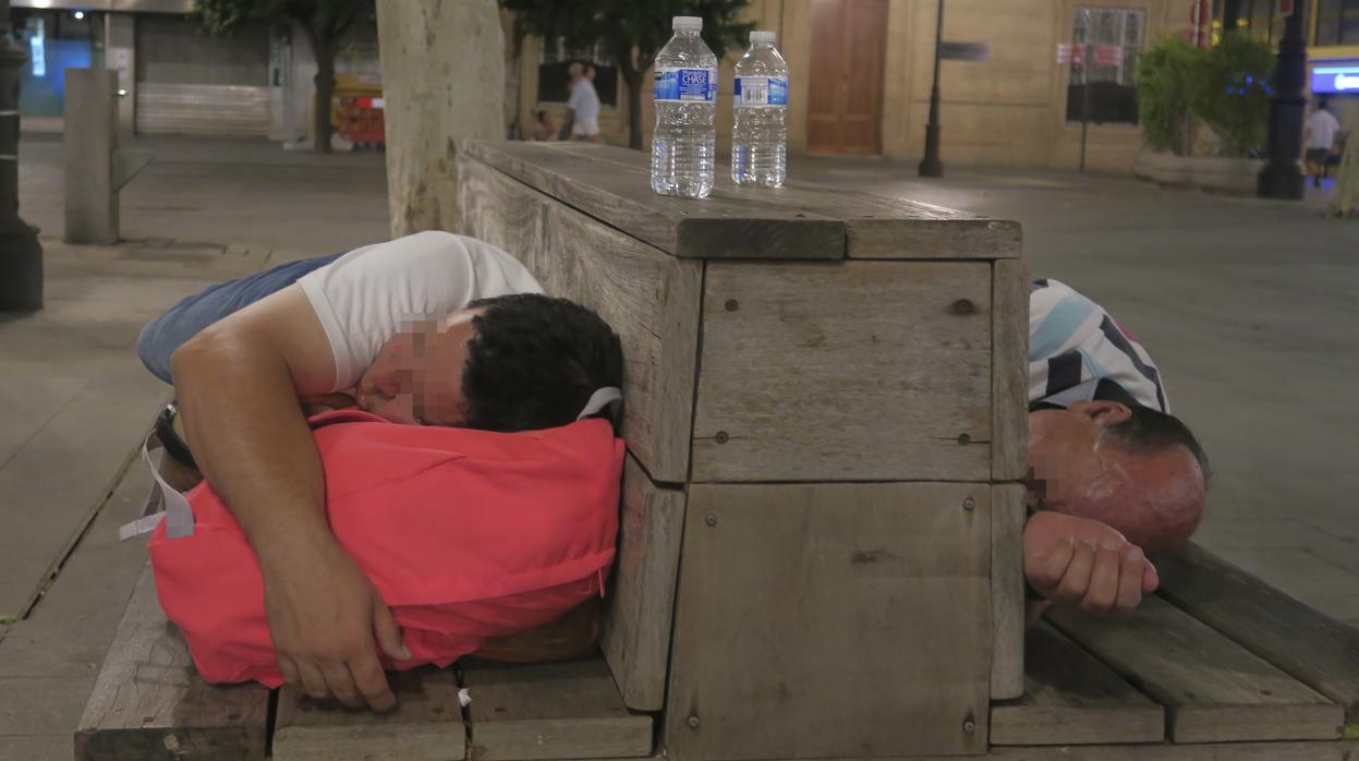 Dos personas sin hogar comparten un banco el pasado martes en la Plaza Nueva