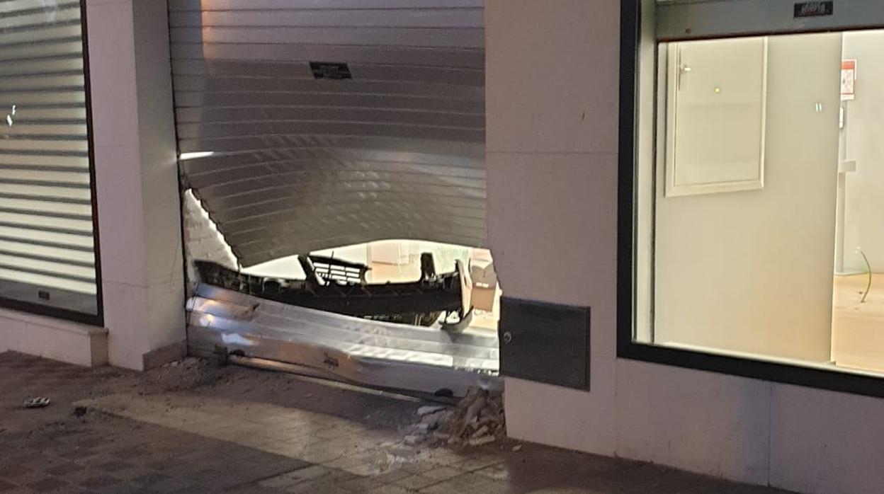 Acceso principal de la tienda destrozado por los aluniceros, que se dejaron el parachoques en la embestida