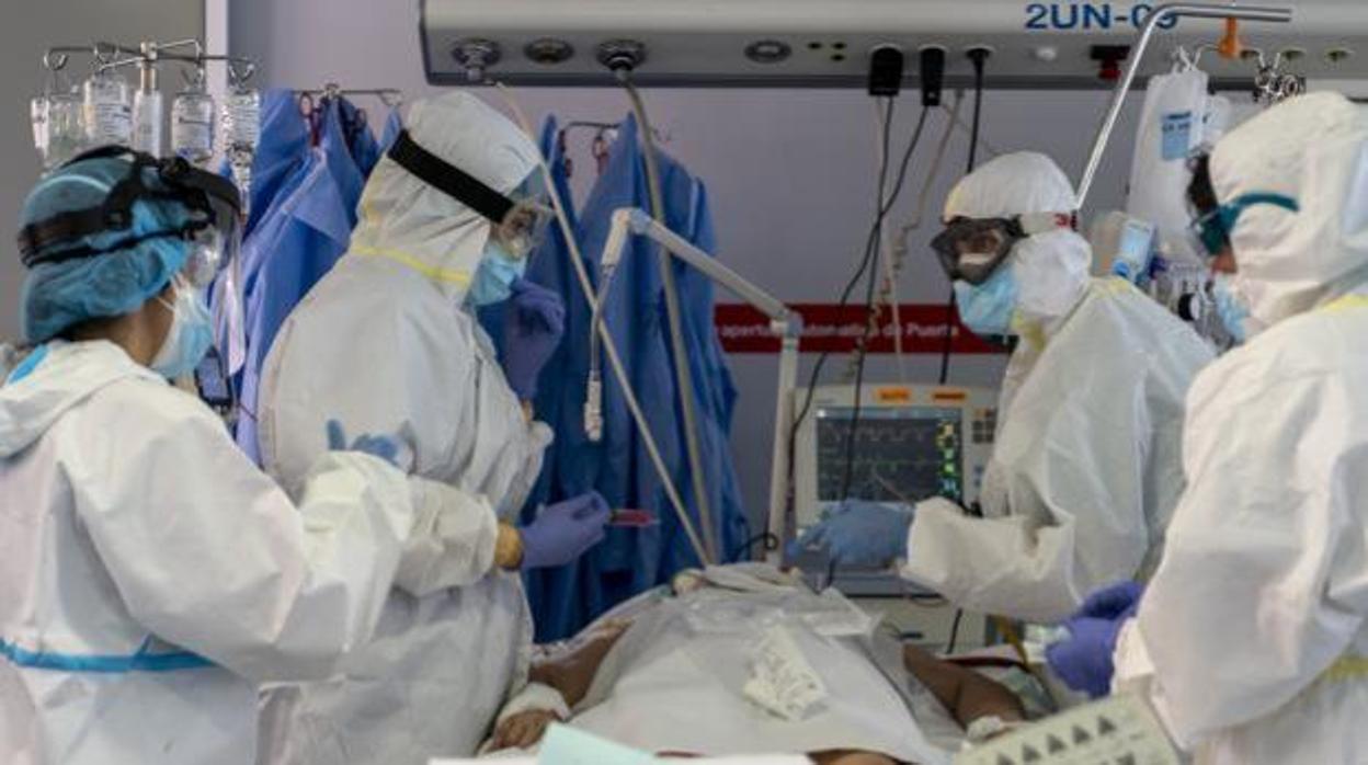 Un grupo de sanitarios atienden a un paciente en la UCI