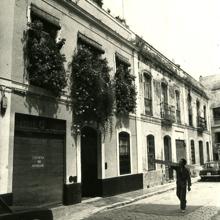 Un hombre camina junto a los balcones florecidos de la calle Céspedes