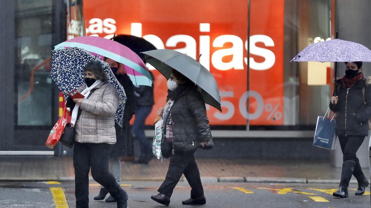 Varias personas se resguardan con paraguas este miércoles en Sevilla capital