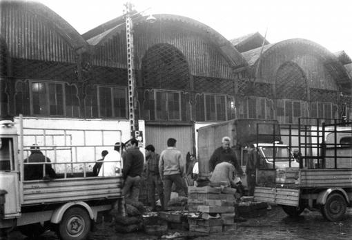 Cajas apiladas, camionetas y trabajadores de la lonja en 1968