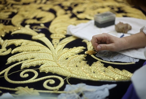 Una artesana bordando un manto para una Virgen