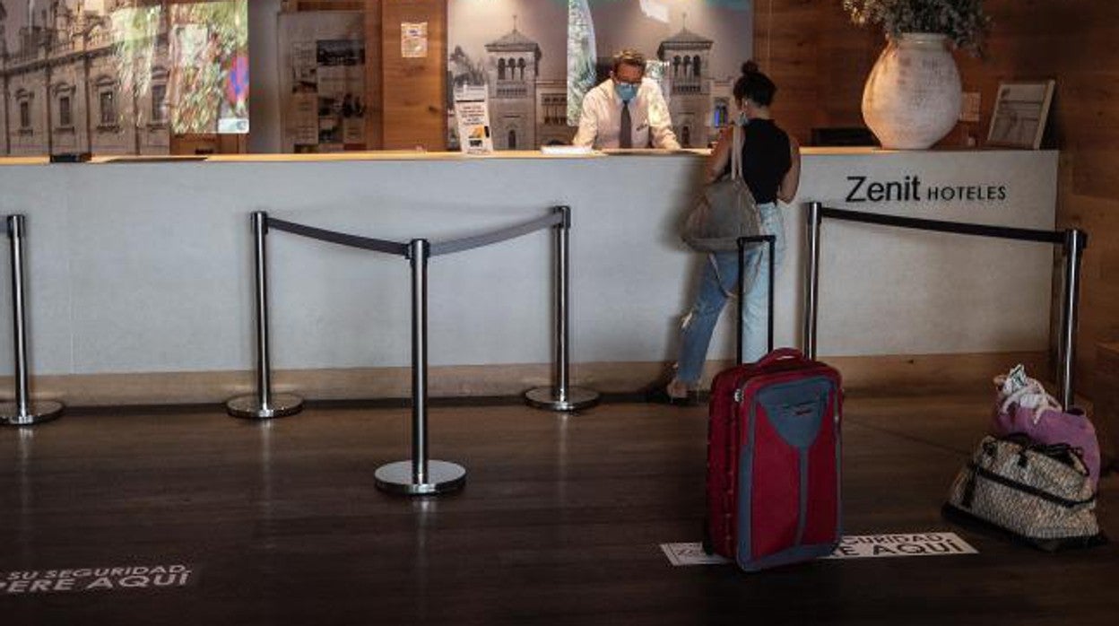 Una huésped se registra en uno de los hoteles sevillanos que sigue abierto