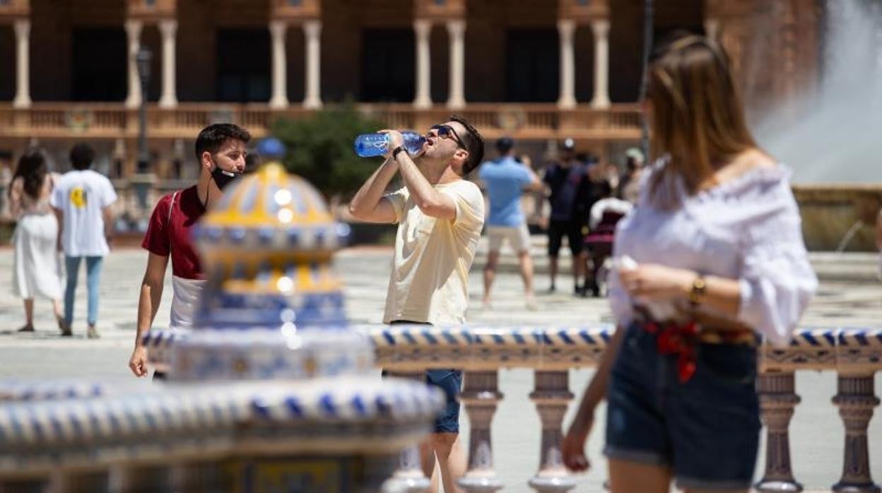 Un joven bebe agua para refrescarse en la Plaza de España