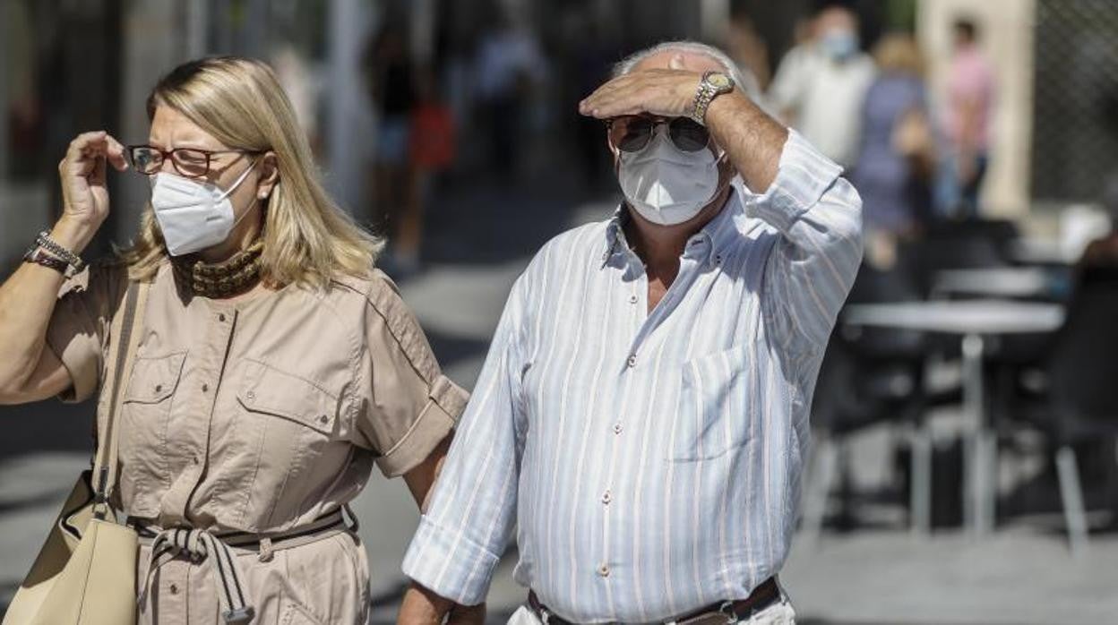 Una pareja pasea con mascarillas por el Centro de Sevilla