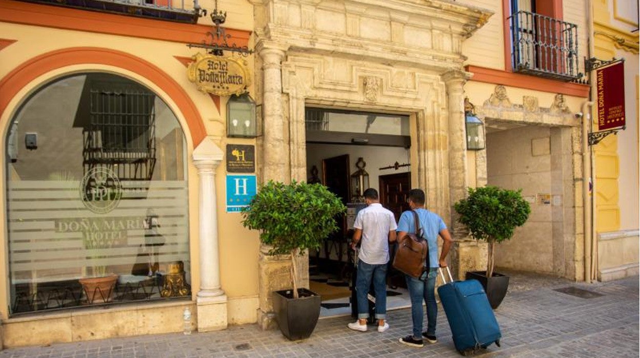 Varios turistas en la puerta del hotel Doña María, en el Centro de Sevilla