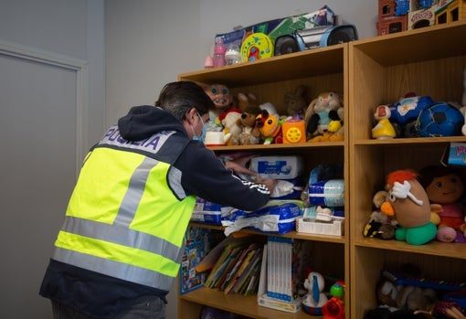 Un agente coloca el material infantil en una sala especial para la atención de los menores