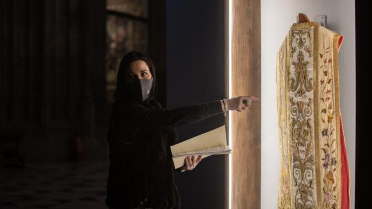 Ana Isabel Gamero muestra una de las casullas bordadas expuestas en el trascoro de la Catedral