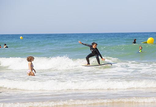 Una niña practicando con su tabla de surf