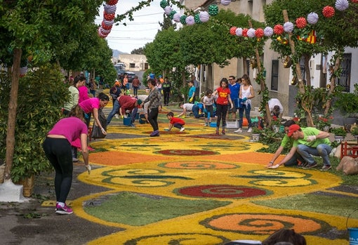 Los vecinos decoran las calles con serrín de colores en Tíjola.