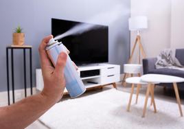 Un hombre pulverizando un spray en su salón