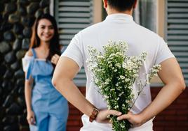 Un joven trata de sorprender a su pareja con un ramo de flores por San Valentín