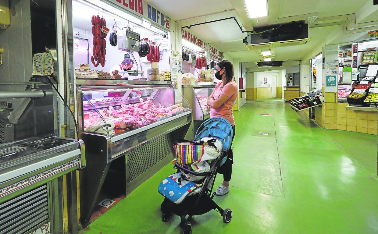 Una mujer hace la compra en un puesto del mercado del Marrubial