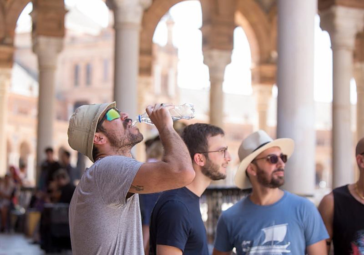 Un joven bebe agua en Sevilla.