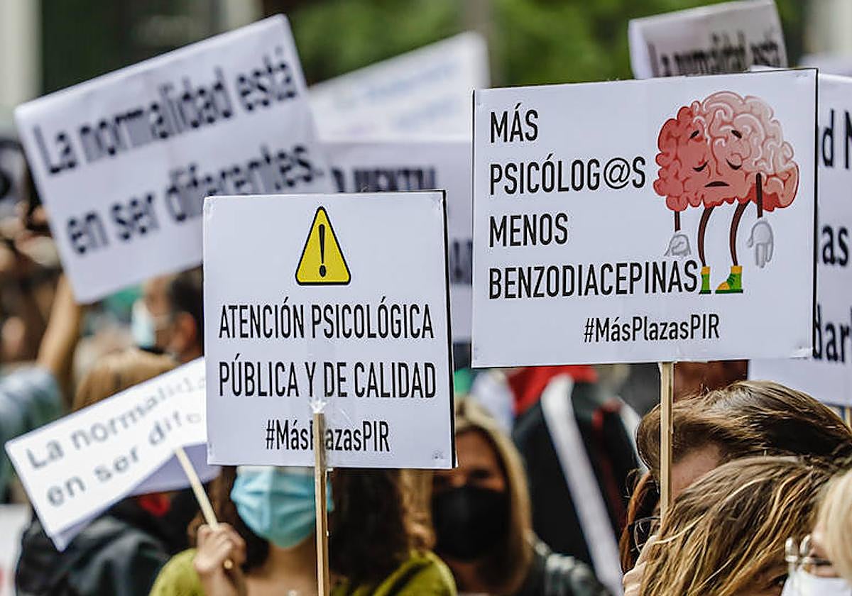 Varias personas sostienen diferentes pancartas en una marcha con motivo del Día Mundial de la Salud Mental.