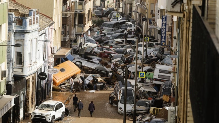 Vehículos amontonados en una calle tras las intensas lluvias de la fuerte en Picaña (Valencia)